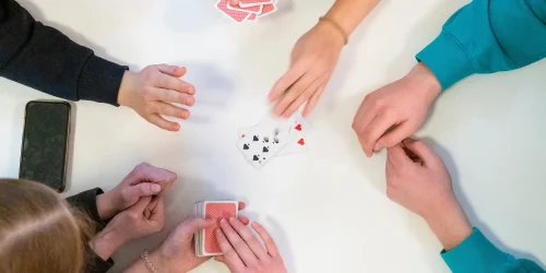 Några ungdomar spelar kort tillsammans.